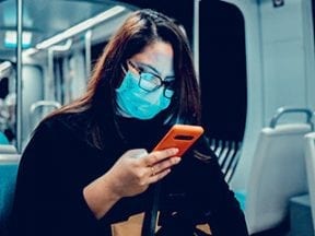 Photo of a female on a subway looking at her smartphone