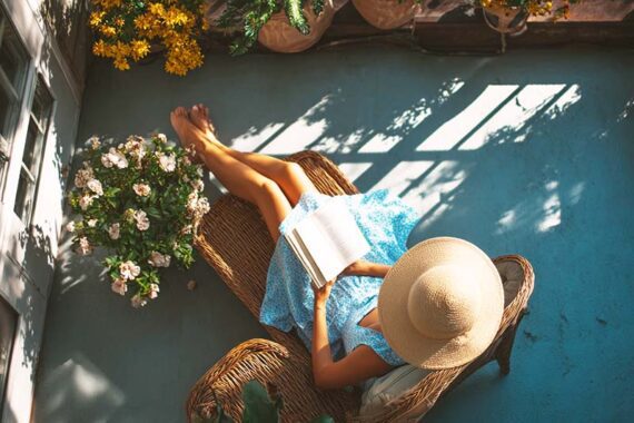 Photo of a female in an outdoor patio reading a book