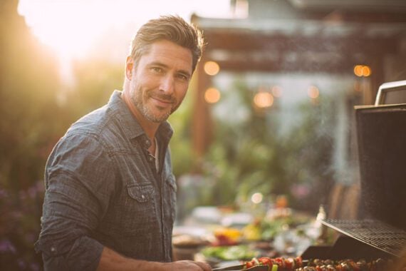 Photo of a male cooking outdoors on a grill Photo of a male cooking outdoors on a grill