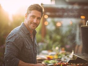 Male cooking outdoors on a grill