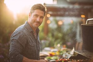 Male cooking outdoors on a grill