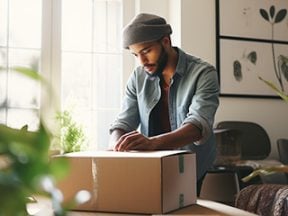 Photo of a merchant preparing a shipping box