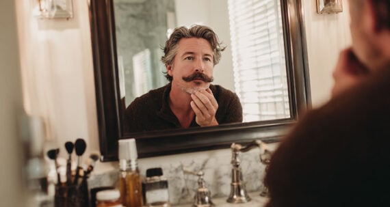 Man with a mustache looking in a mirror Man with a mustache looking in a mirror