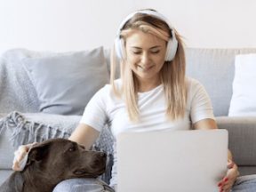 Photo from Notta of a female wearing headphones holding a laptop