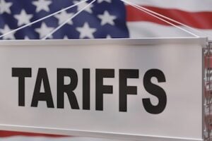 Illustration of a shipping container with "Tariffs" on the side in front of a U.S. flag