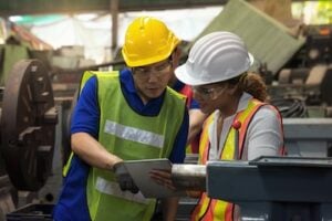 Photo of two workers (male and female) in a manufacturing environment
