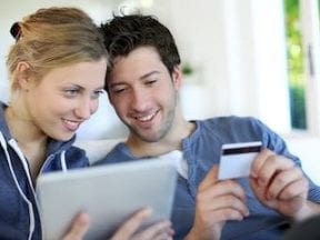 Image of a young married couple shopping on a computer