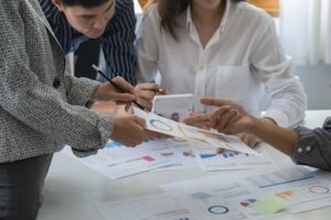 Image of three people at a table looking at charts