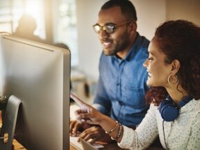 Male and female in an office looking at a computer