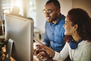 Male and female in an office looking at a computer