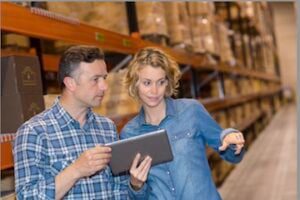 Photo of male and female holding a tablet in a warehouse