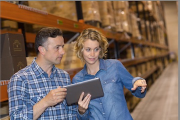 Photo of male and female holding a tablet in a warehouse