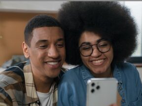 Image of a male and female influencers talking into a smartphone