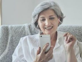 Photo of a middle-aged female using a smartphone.