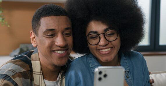 Male and female inflluencers holding a smartphone