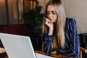Photo from MoreDraw of a female at a desk looking at a laptop computer