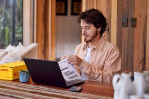 Photo from DHL Group of a male looking at a laptop