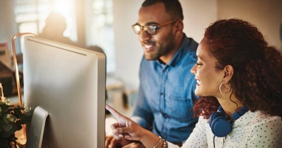 Male and female in an office looking at a computer