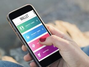 Photo of a person holding a smartphone with a mobile wallet on the screen