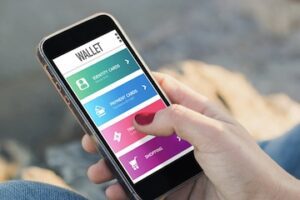 Photo of a person holding a smartphone with a mobile wallet on the screen